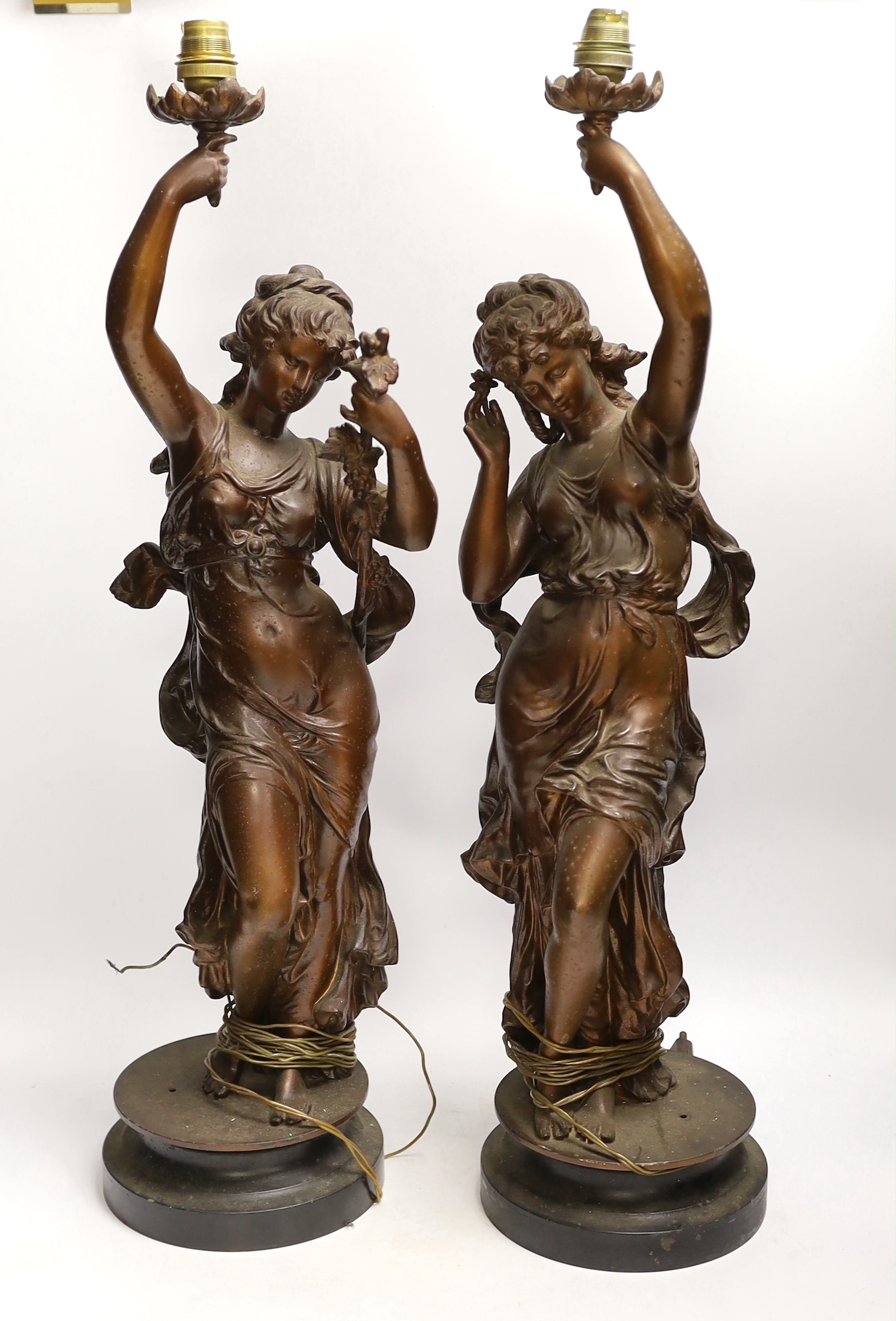 A pair of patinated spelter figural lamp bases, 63cm high not including light fitting